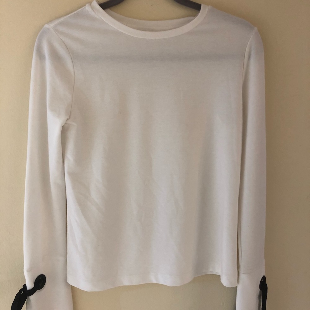 White sweater with loop and tie on sleeve